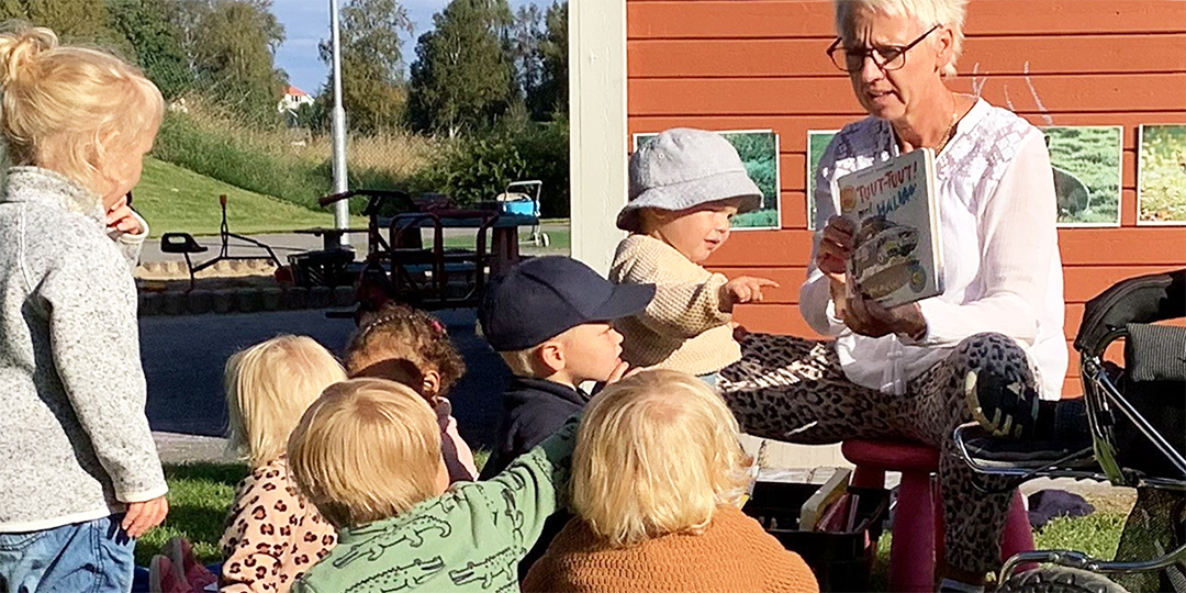 högläsning utomhus pedagog och barn